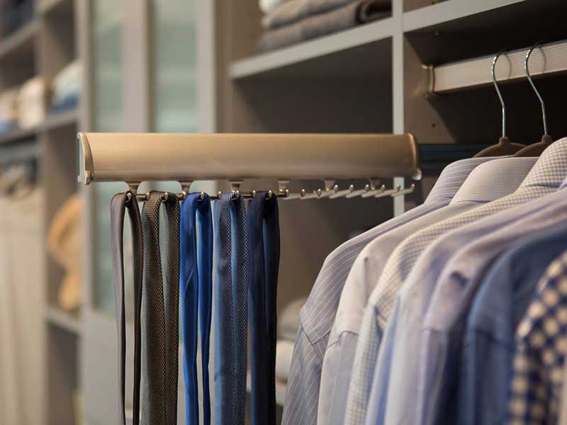 a photo of a retractable tie rack in a closet.